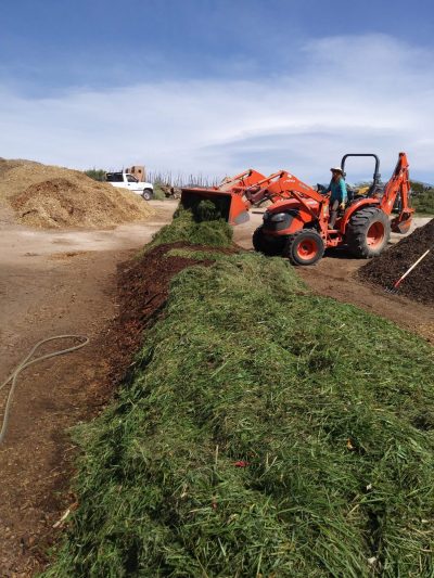 Building a windrow of bulk compost.